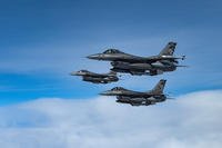 Three F-16 Fighting Falcons fly alongside a KC-135 Stratotanker.
